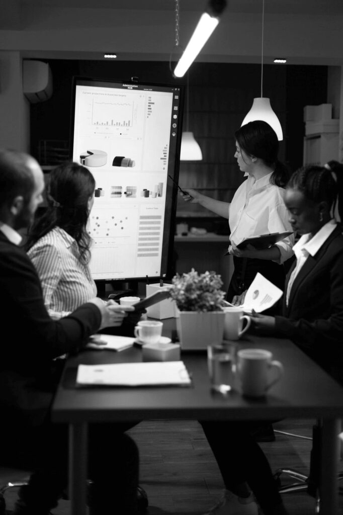 Photo d'un groupe de personnes en réunion dans une salle analysant les données de produits affichés sur une écran au niveau de la page à propos de Semen Africa